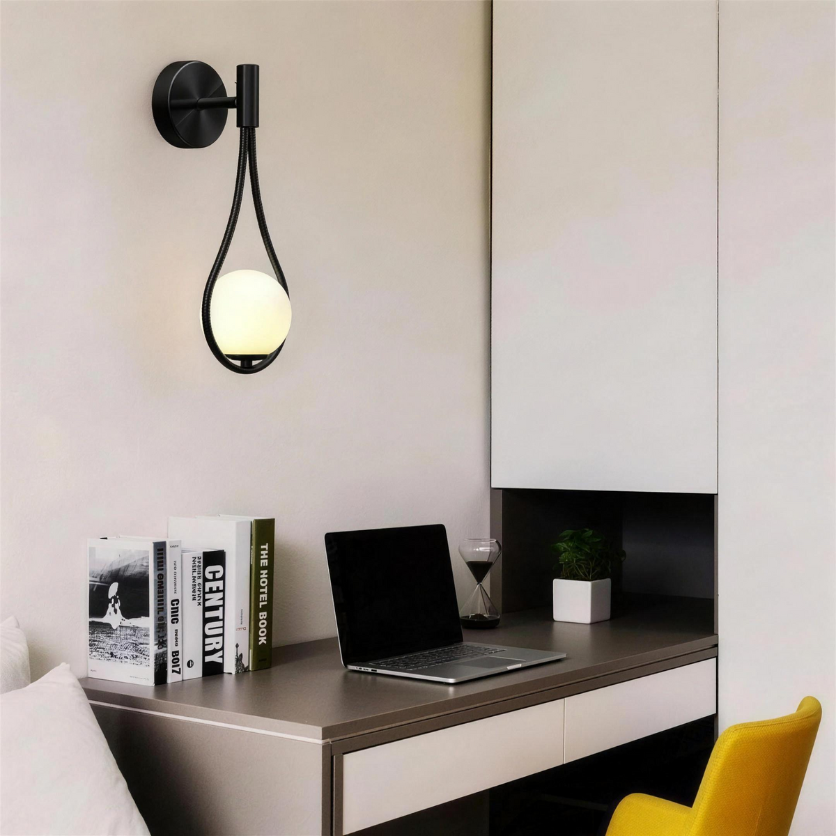Black teardrop globe wall sconce above a desk in a bright home office