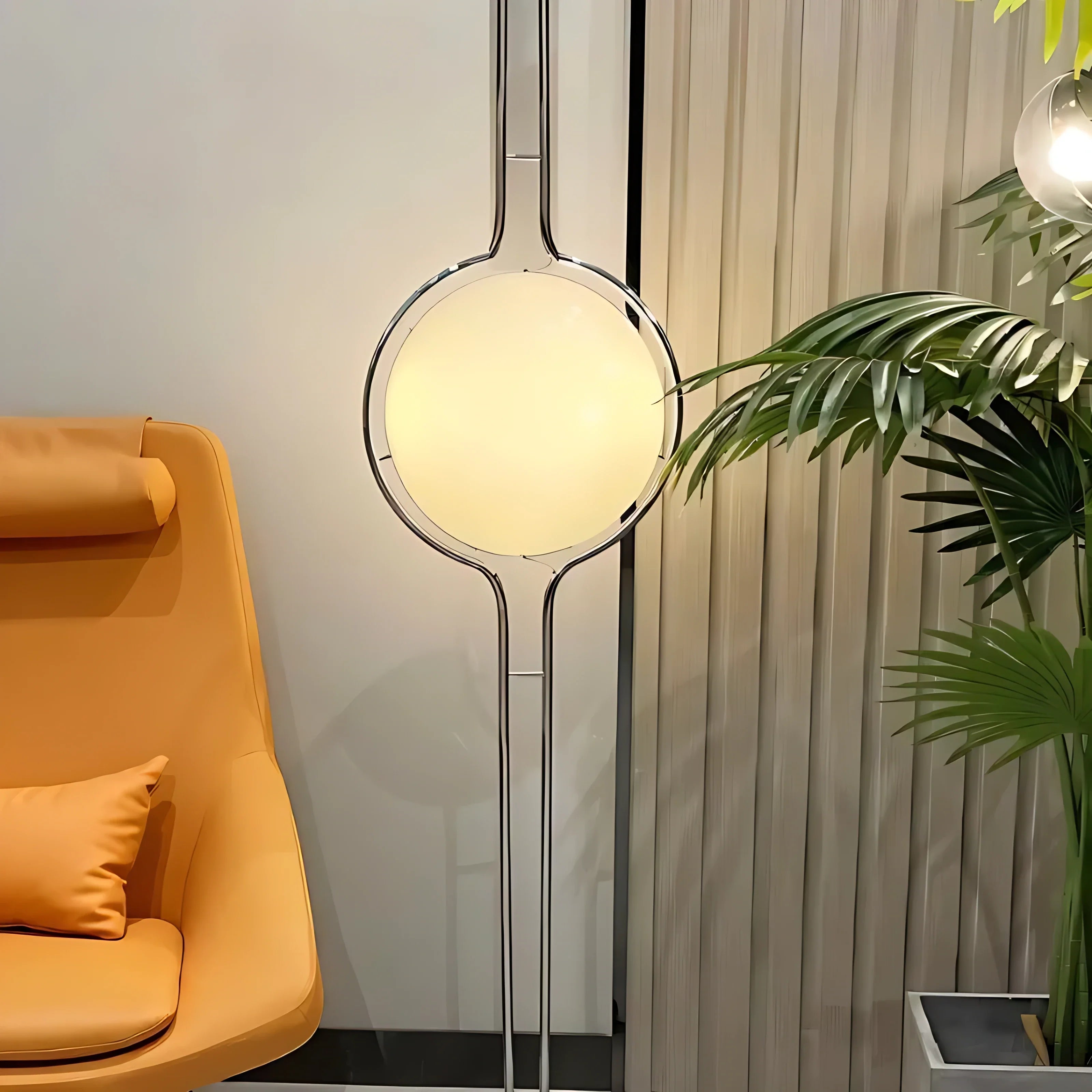 Chrome Sfera Sospesa floor-to-ceiling globe lamp beside an armchair